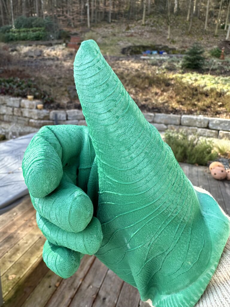 Hand in grünem Handschuh